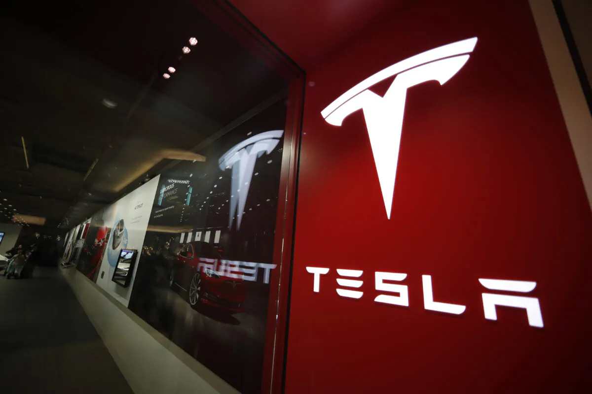 A file photo of a sign bearing the company logo outside a Tesla store in Cherry Creek Mall in Denver. (David Zalubowski, File/AP Photo)