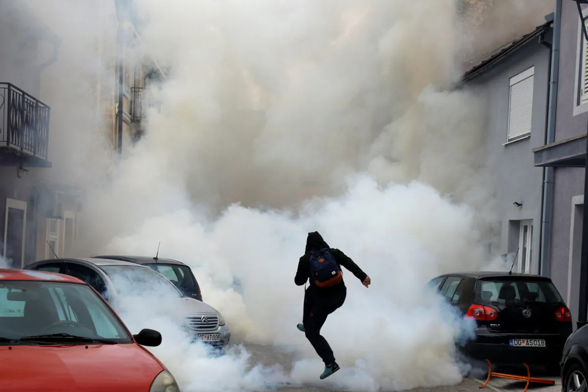 A demonstrator is covered in tear gas during a protest against the enthronement of Bishop Joanikije in Cetinje, Montenegro, on Sept. 5, 2021. (Stevo Vasiljevic/Reuters)