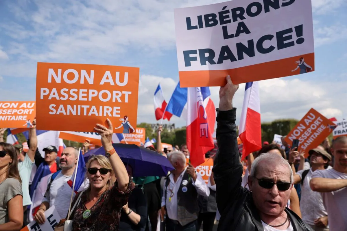 People hold placards reading, "no to the sanitary pass" (L) and "let's liberate France" during a demonstration  in Paris on September 4, 2021 (THOMAS COEX/AFP via Getty Images)