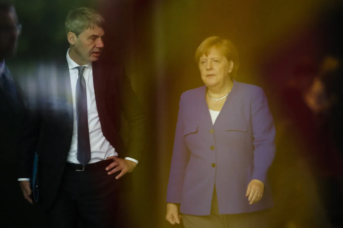 German Chancellor Angela Merkel (R), talks to then foreign policy advisor Jan Hecker (L), as she arrives to welcome the Prime Minister of North Macedonia Zoran Zaev for a meeting at the chancellery in Berlin on June 13, 2019. (AP Photo/Markus Schreiber, File)