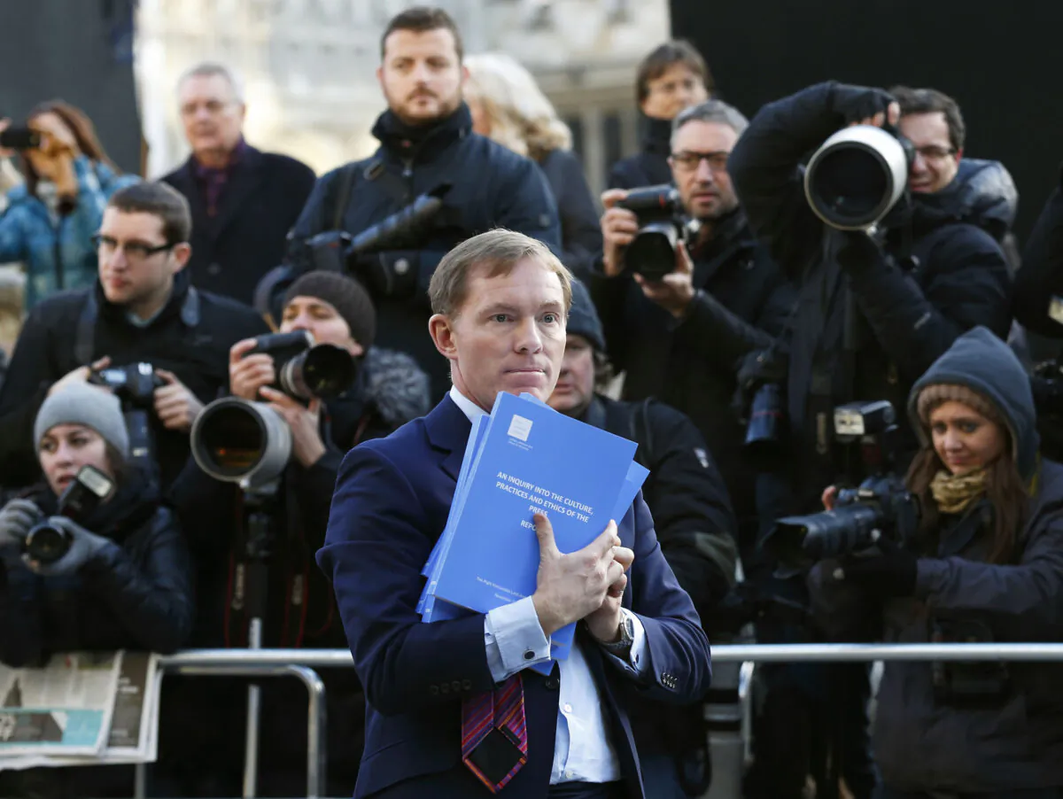 British opposition Labour member of parliament Chris Bryant poses for photographers with a copy of the Leveson Report into press ethics in central London on Nov. 29, 2012. (Justin Tallis/AFP via Getty Images)