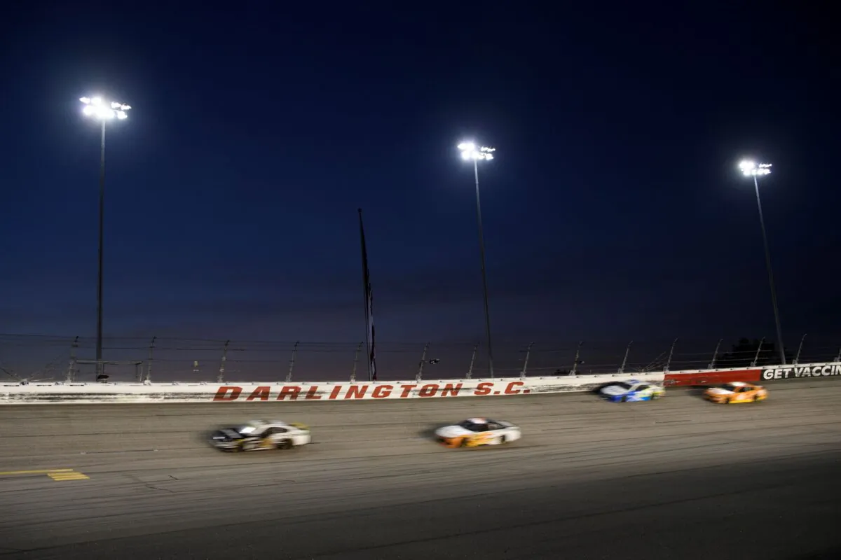 Cars race under the lights during a NASCAR Cup Series auto race in Darlington, S.C., on Sept. 5, 2021. (John Amis/AP Photo)