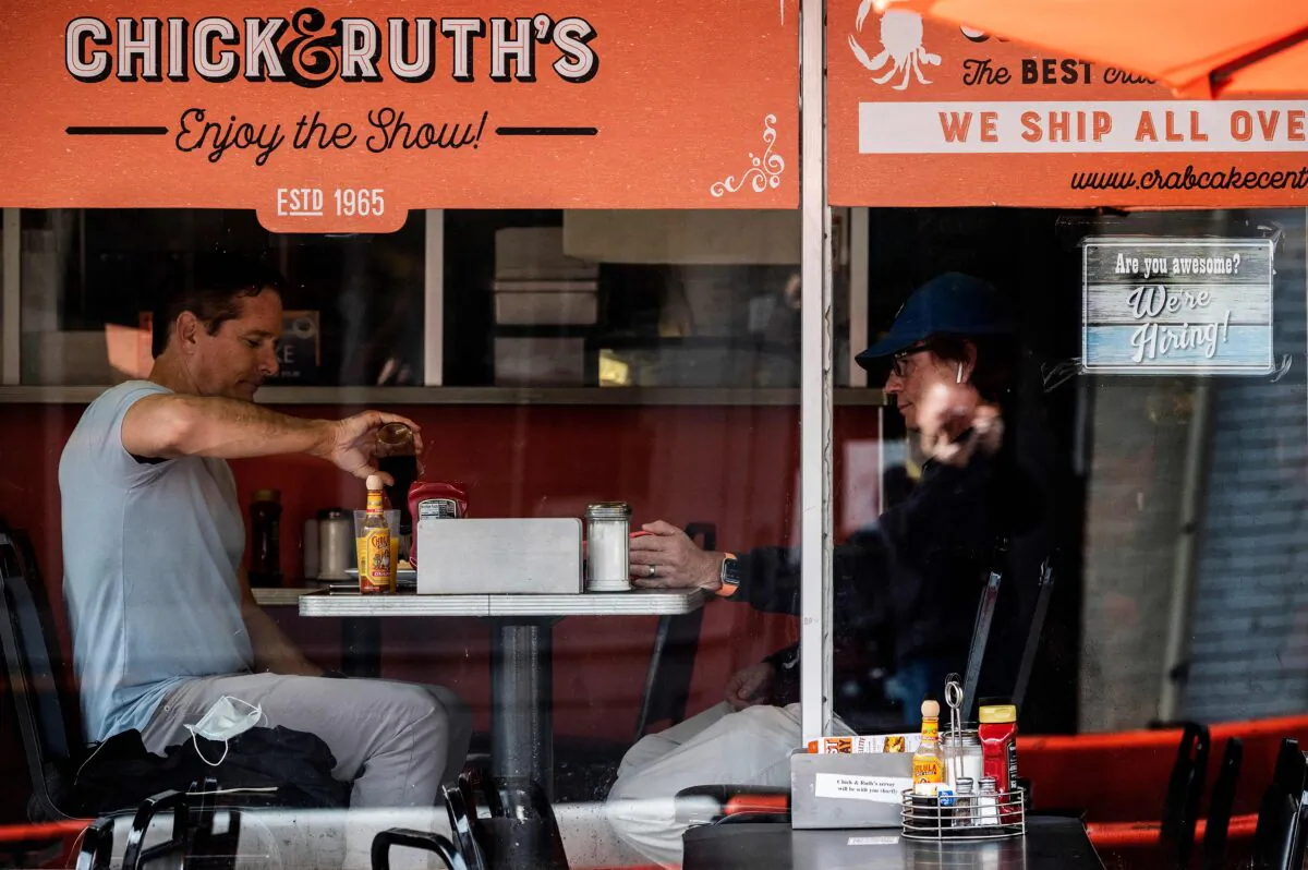 People eat breakfast at a restaurant that's advertising that they're hiring in Annapolis, Md., on May 12, 2021. (Jim Watson/AFP via Getty Images)