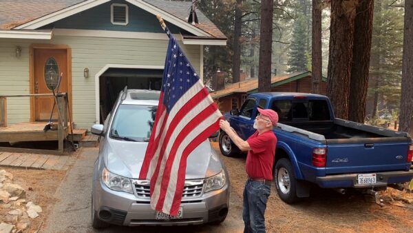man-rolls-up-flag