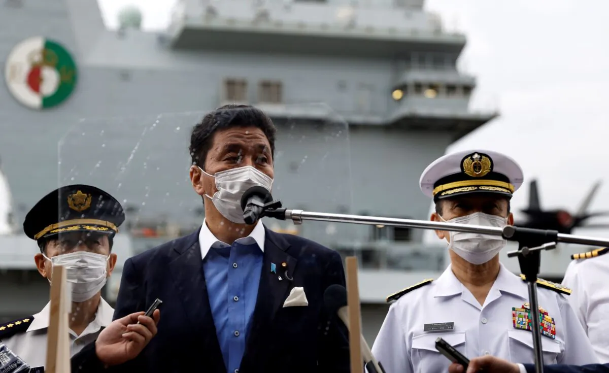 Japan's Defense Minister Nobuo Kishi (C) speaks to the members of the media after he inspected the British Royal Navy's HMS Queen Elizabeth aircraft carrier (back), at the U.S. naval base in Yokosuka, Kanagawa Prefecture, Japan on Sept. 6, 2021. (Kiyoshi Ota/Pool Photo via AP)