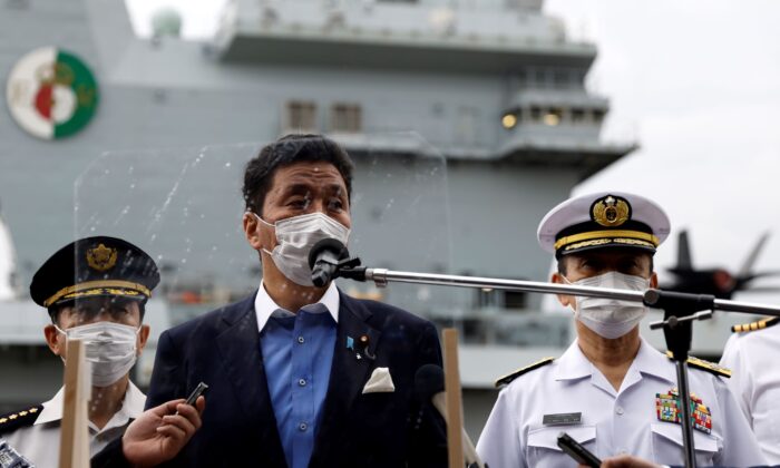 Japan's Defense Minister Nobuo Kishi (C) speaks to the members of the media after he inspected the British Royal Navy's HMS Queen Elizabeth aircraft carrier, back, at the U.S. naval base in Yokosuka, Kanagawa Prefecture, Japan on Sept. 6, 2021. (Kiyoshi Ota/Pool Photo via AP)