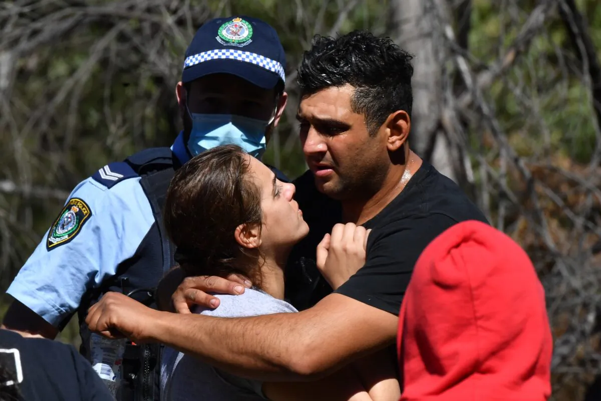 An emotional Anthony and Kelly Elfalak, the mother and father of AJ, hugs family and friends when they learn the boy has been found alive on the family property near Putty south west of Sydney, Monday, September 6, 2021. (Dean Lewins/AAP Image)