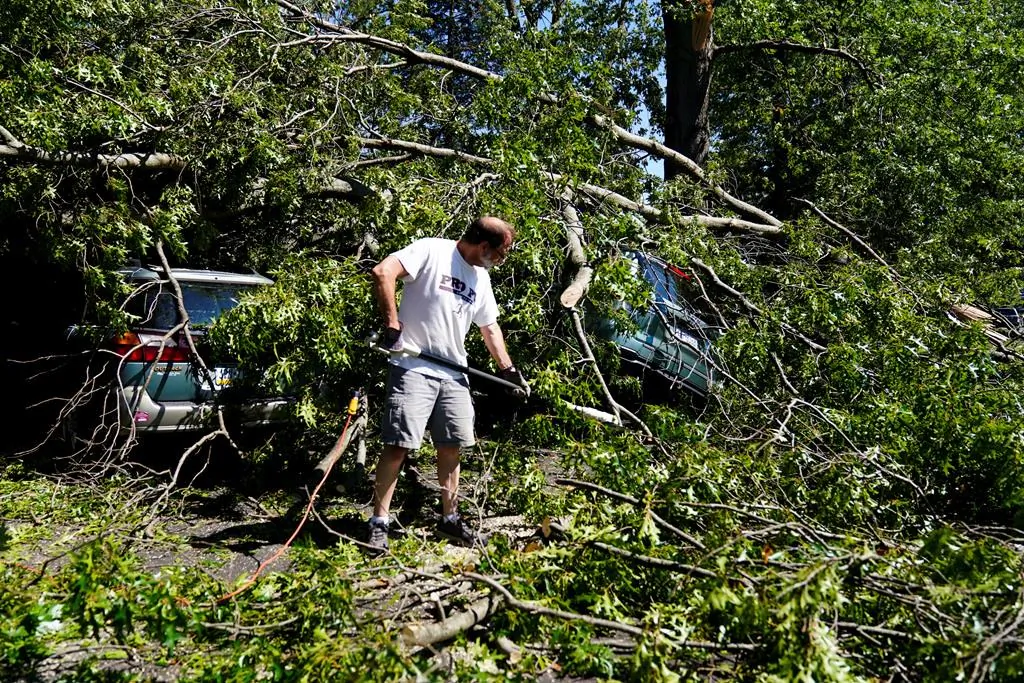 Larry Ackley helps clear a downed tree a fellow church member's home in Fort Washington, Pa. on Sept. 2, 2021 in the aftermath of downpours and high winds from the remnants of Hurricane Ida that hit the area. (AP Photo/Matt Rourke)