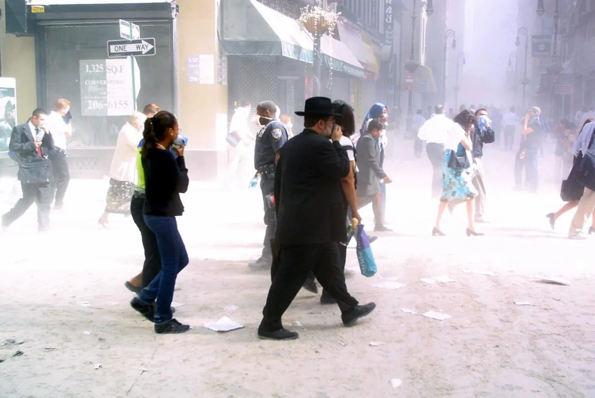 Pedestrians make their way through the dust of lower Manhattan in New York on Sept. 11, 2001, after two hijacked planes were flown into the World Trade Center. (Doug Kanter/AFP via Getty Images)