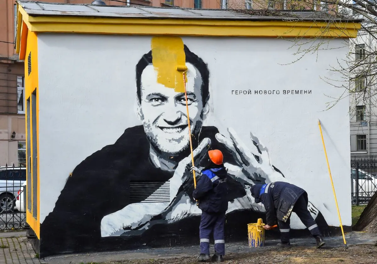 A worker paints over graffiti of jailed Kremlin critic Alexei Navalny in St. Petersburg on April 28, 2021. The inscription reads: "The hero of the new times". (Olga Maltseva/AFP via Getty Images)