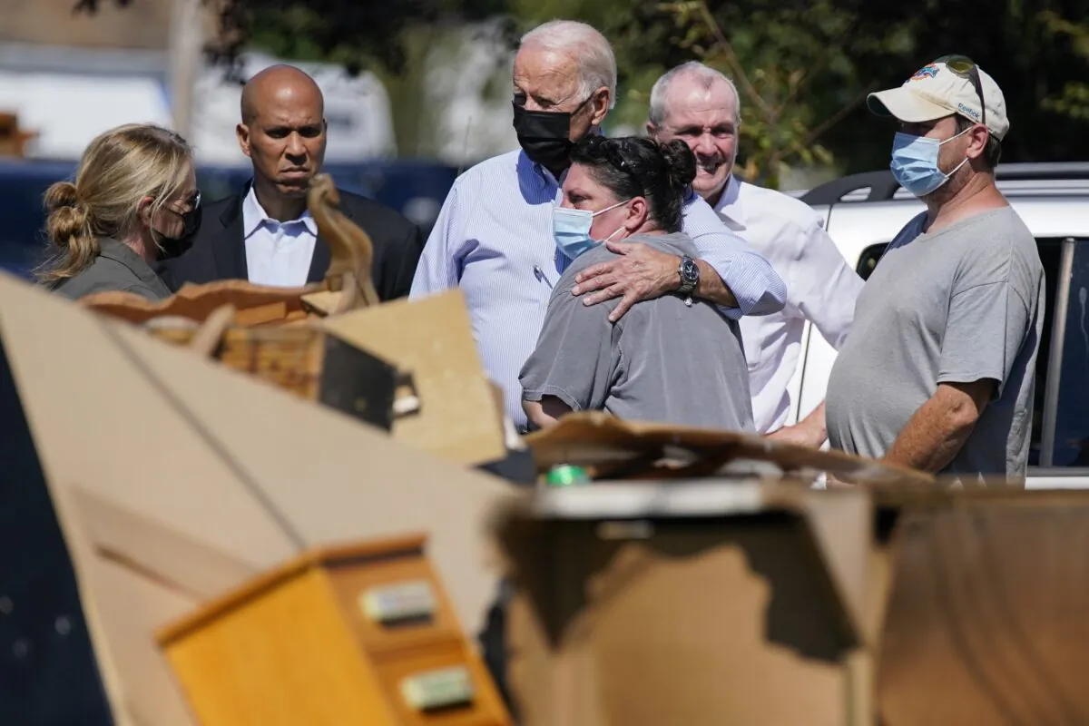 President Joe Biden hugs a woman as Sen. Cory Booker (D-N.J.) (2nd L), New Jersey Gov. Phil Murphy, (2nd R), and others look on as officials tour a neighborhood impacted by Hurricane Ida in Manville, N.J., on Sept. 7, 2021. (Evan Vucci/AP Photo)