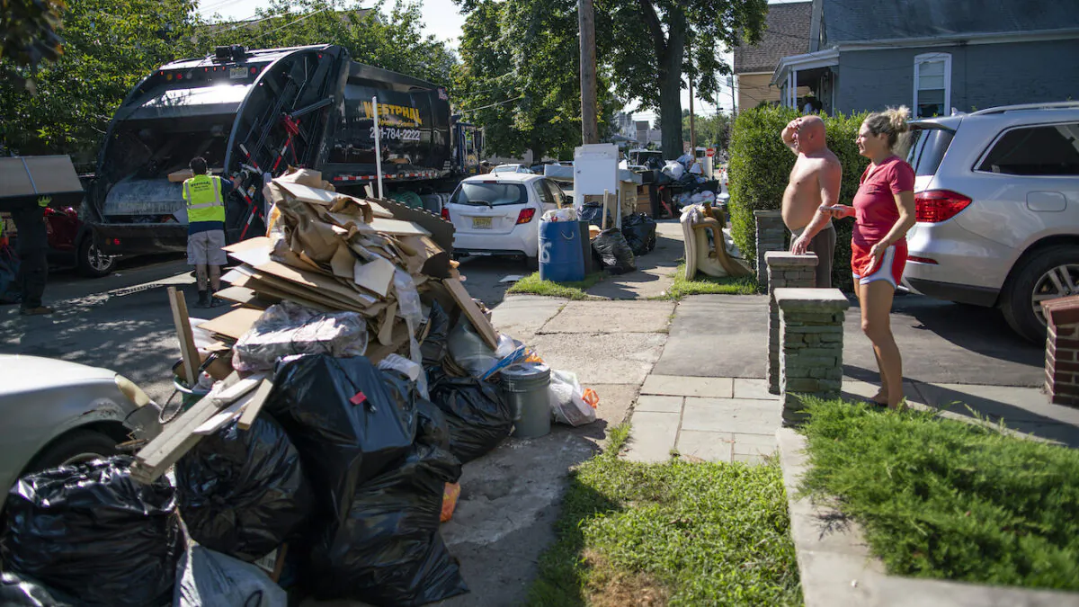 Residents wait a worker picking up debris in Passaic, NJ., from their flood damaged home in the aftermath of Hurricane Ida, on Sept. 6, 2021. (AP Photo/Eduardo Munoz Alvarez)