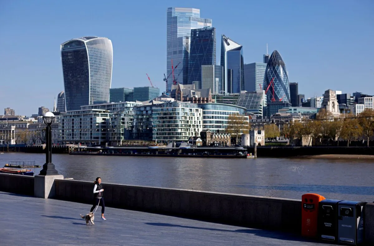 A woman exercises with a dog near the City of London financial district, in London, UK, on April 30, 2021. (John Sibley/Reuters)