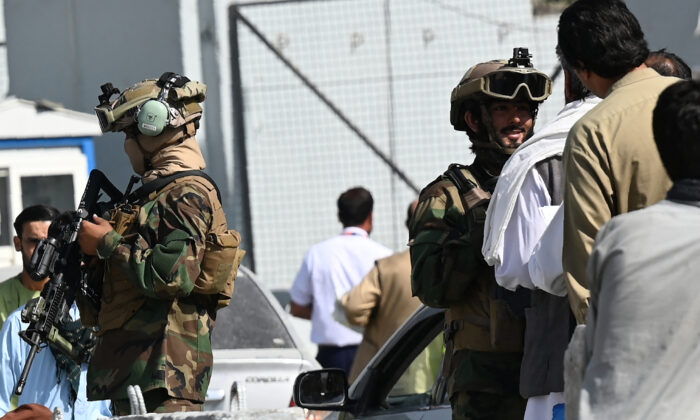 Taliban terrorists stand guard at a checkpoint as airport workers queue to enter to the Kabul International Airport in Kabul on Sept. 4, 2021. (Aamir Qureshi/AFP via Getty Images)