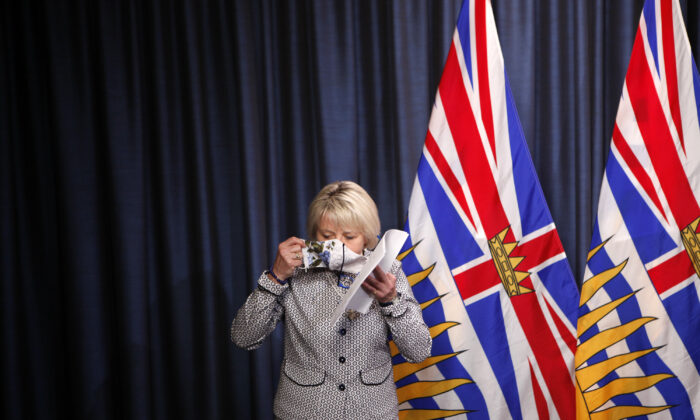 B.C. Provincial Health Officer Dr. Bonnie Henry puts on her mask following discussion of details about the COVID-19 vaccine card set to arrive in mid-September 2021, at a press conference at the provincial legislature in Victoria on Aug. 23, 2021. (The Canadian Press/Chad Hipolito)