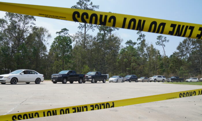 Caution tape stretches between gas pumps as a line of cars waits in a file photo. (Jackson Elliott/The Epoch Times)