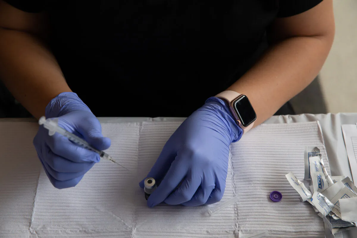 An emergency preparedness specialist from the Oakland County Health Department fills a syringe with a COVID-19 vaccine dose at the Southfield Pavilion in Southfield, Michigan, on Aug. 24, 2021. (Emily Elconin/Getty Images)