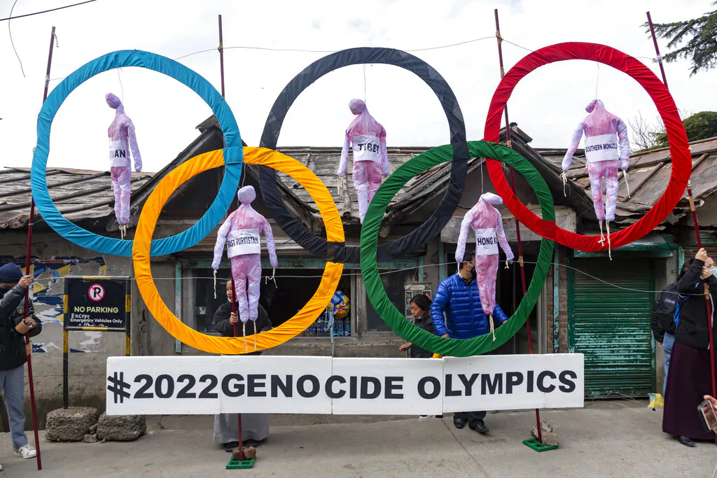 Exile Tibetans use the Olympic Rings as a prop as they hold a street protest against the holding of 2022 Winter Olympics in Beijing, in Dharmsala, India, on Feb. 3, 2021. (Ashwini Bhatia/AP Photo)