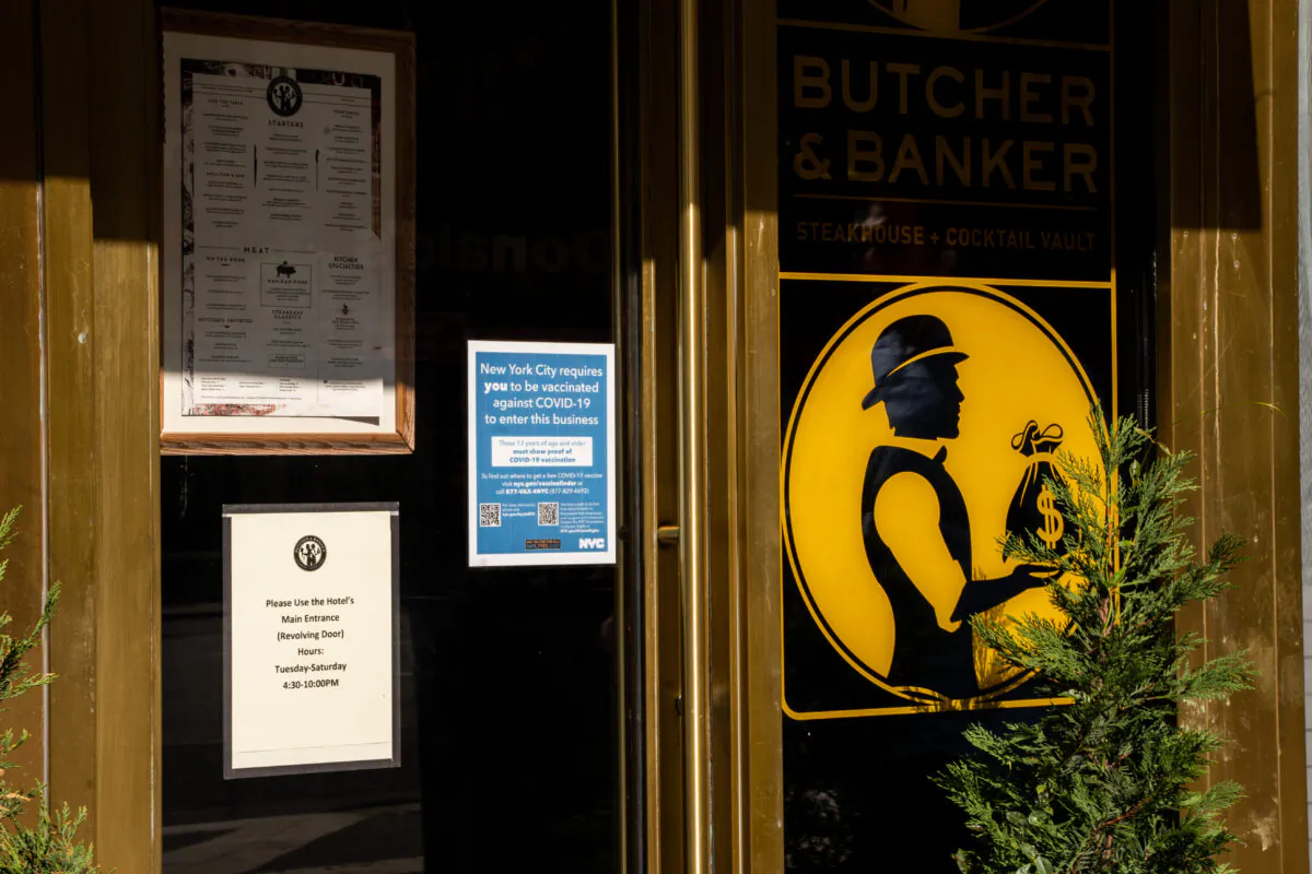 Vaccine proof requirement note displays at a restaurant store front in New York on Sept. 7, 2021. (Chung I Ho/The Epoch Times)