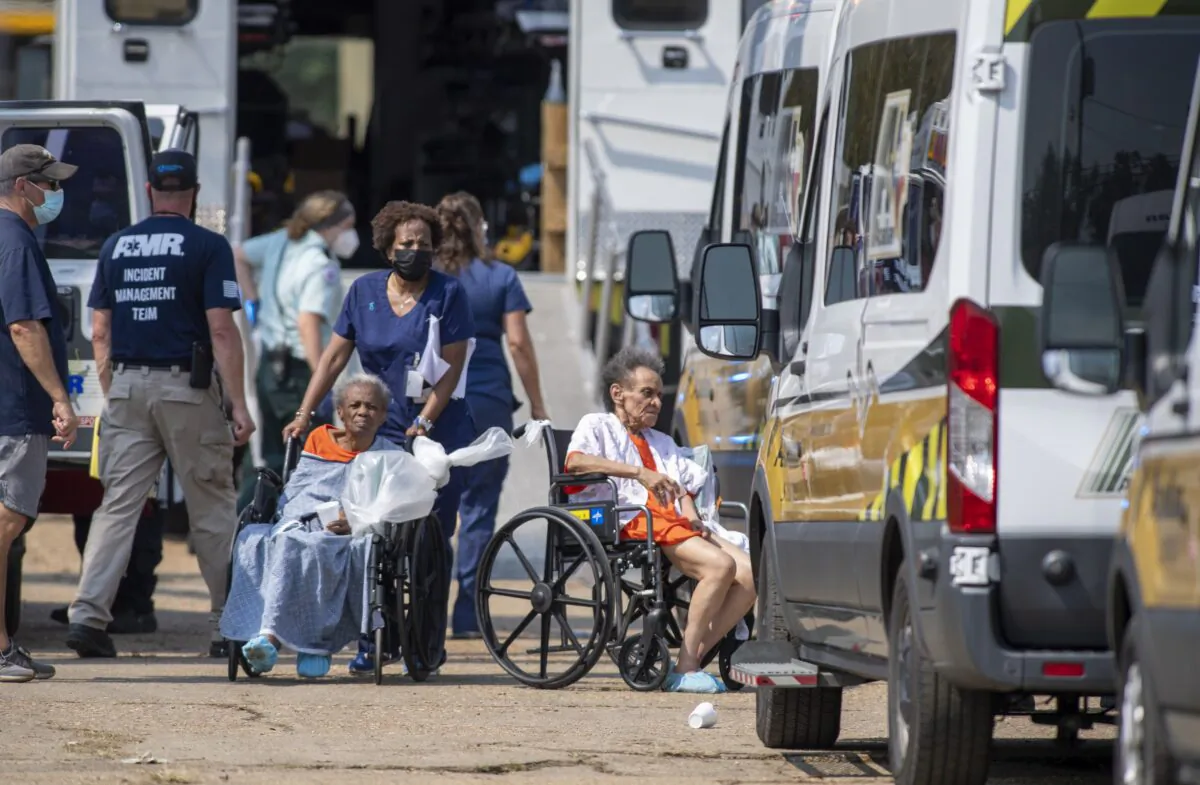 Paramedics evacuate people at a mass shelter in Independence, La., on Sept. 2, 2021. (Chris Granger/The Times-Picayune/The New Orleans Advocate via AP)