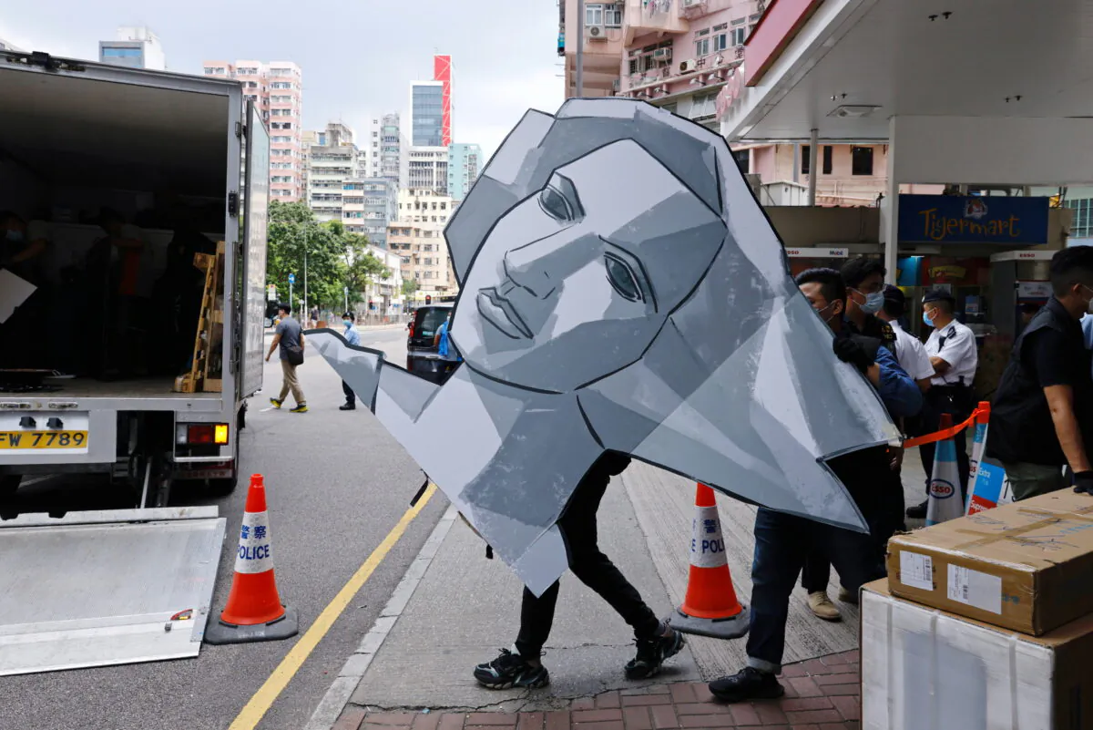 Police collect a cut out of the Goddess of Democracy at the June 4th Museum, which commemorates the 1989 Tiananmen Square crackdown, as they search the museum after arresting four members of the Hong Kong Alliance in Support of Patriotic Democratic Movements in China, in Hong Kong, China, on Sept. 9, 2021. (Tyrone Siu/Reuters)