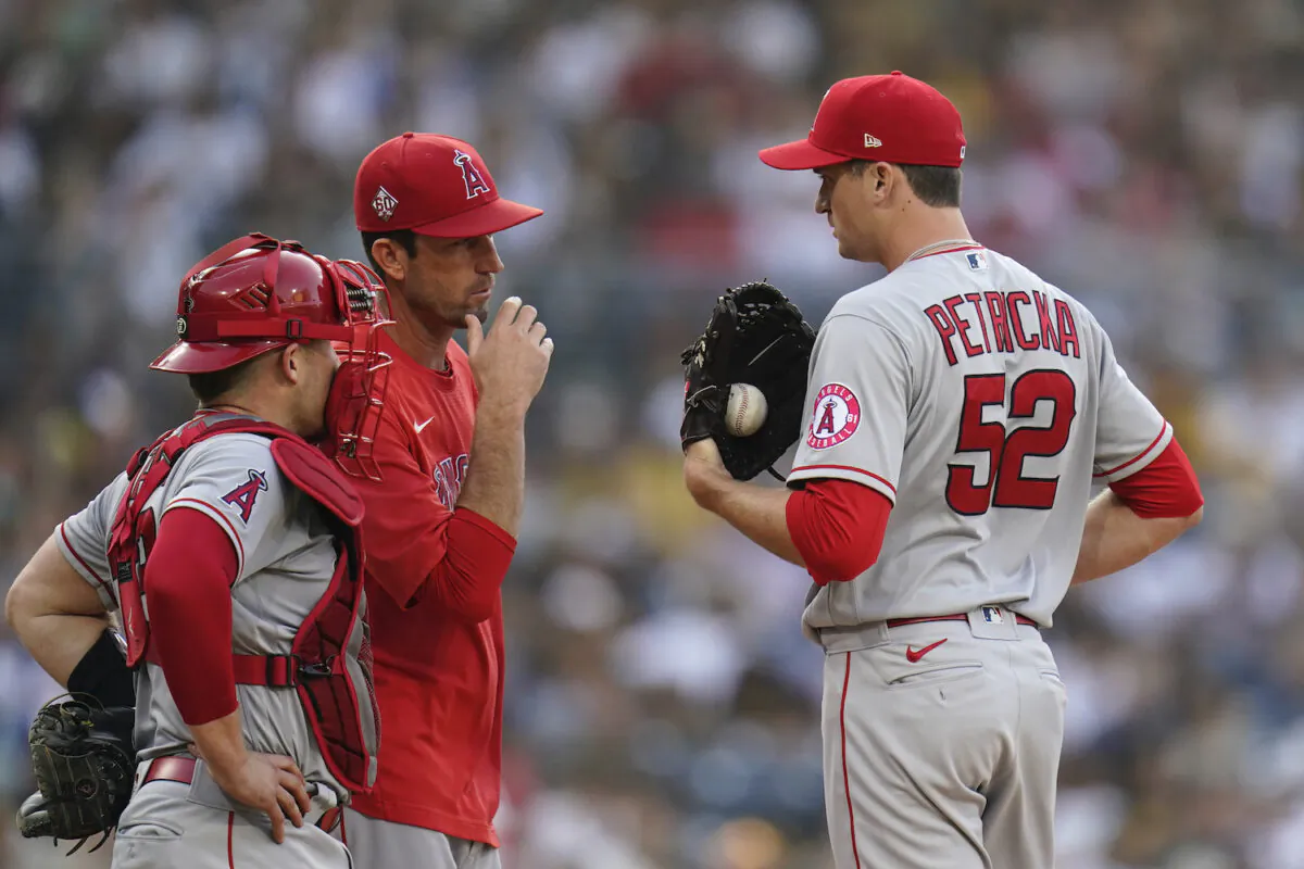 Los Angeles Angels relief pitcher Jake Petricka (52) talks with pitching coach Matt Wise, center, as catcher Max Stassi looks on during the second inning of a baseball game against the San Diego Padres in San Diego, Calif., on Sept. 8, 2021. (AP Photo/Gregory Bull)