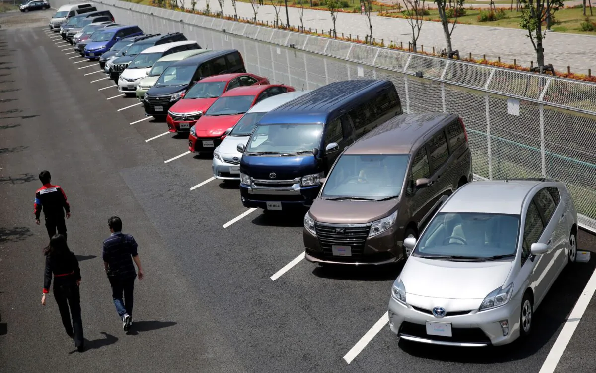 People walk beside test-driving cars outside a car maker's showroom in Tokyo on May 1, 2014. (Toru Hanai/Reuters)