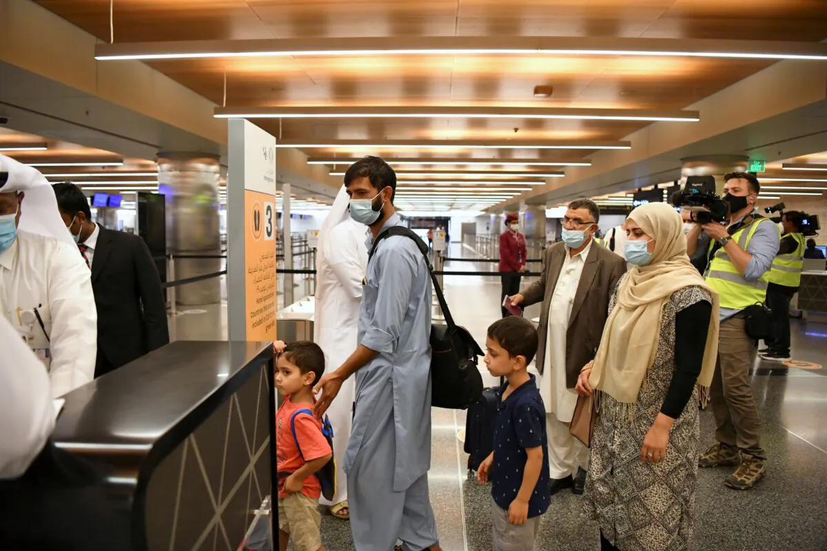 Passengers wait in line in the airport terminal upon arriving on a Qatar Airways plane from Kabul, Afghanistan, the first international commercial flight since the U.S. withdrawal from Afghanistan, in Doha, Qatar, on Sept. 9, 2021. (Nooman Ben Amor/Reuters)