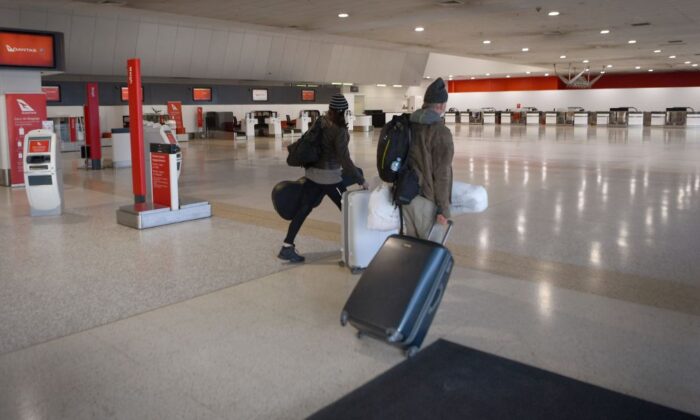 Travellers walk through a deserted Qantas terminal at Melbourne Airport in Melbourne, Australia on Aug. 26, 2021 (William West/AFP via Getty Images)