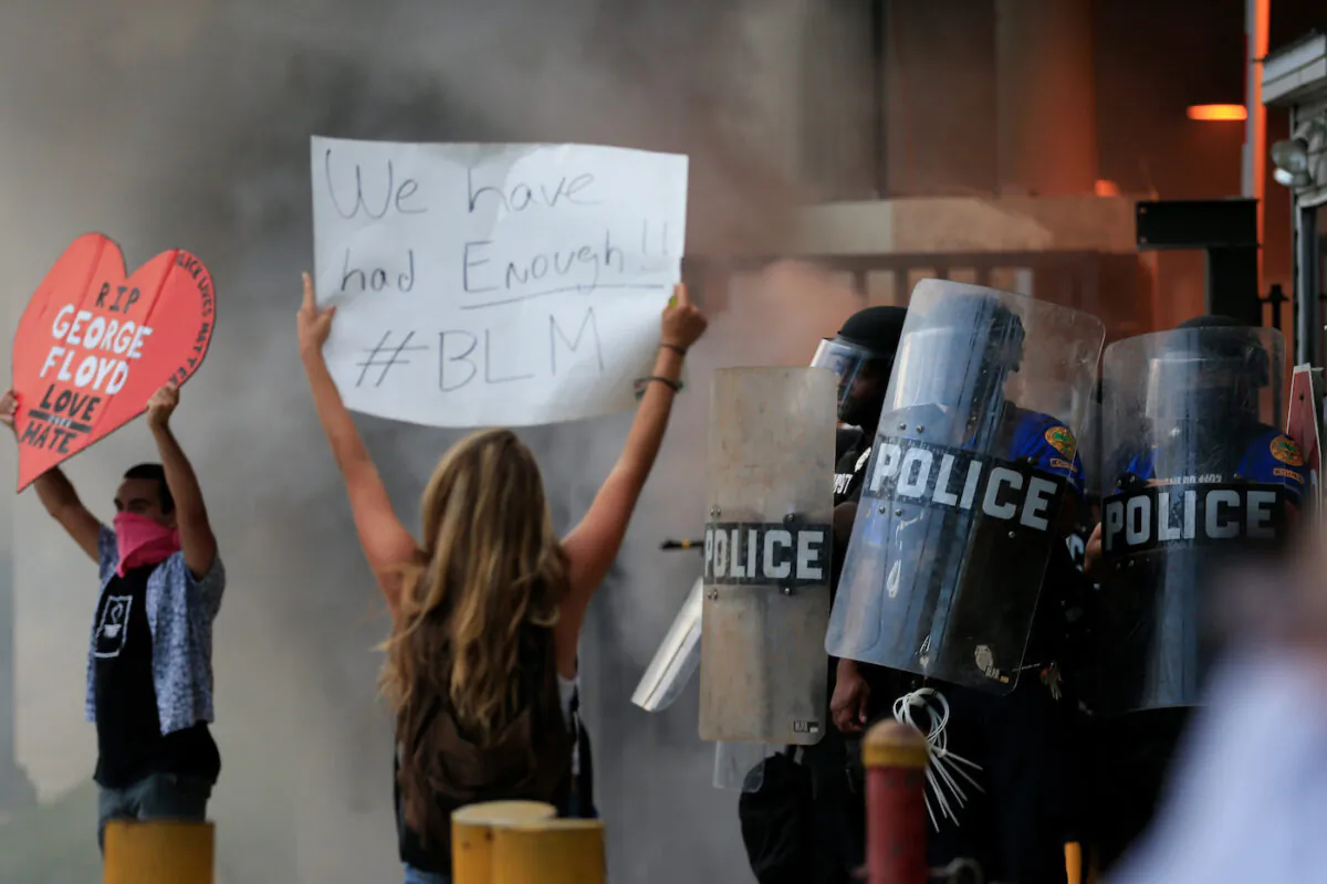 Police in riot gear face a protest outside a police station against the killing George Floyd on May 30, 2020, in Miami. (Cliff Hawkins/Getty Images)