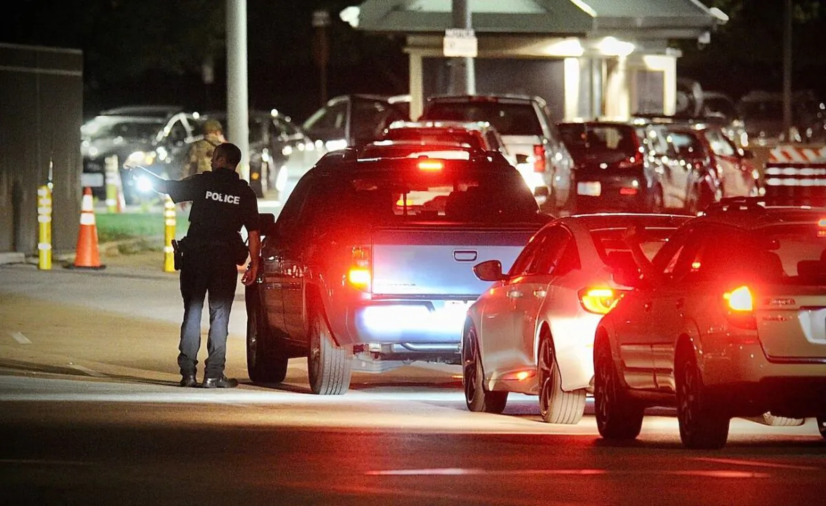 A police officer talks to a driver at a gate at Wright-Patterson Air Force Base, Ohio, near Dayton, on Sept. 9, 2021. (Marshall Gorby/Dayton Daily News via AP)