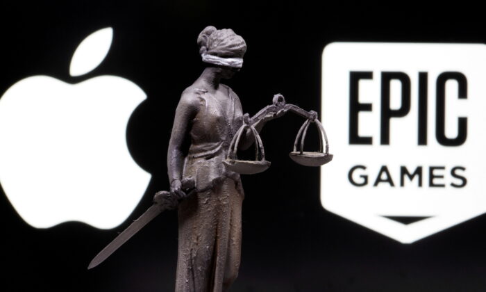 3D printed Lady Justice figure is seen in front of displayed Apple and Epic Games logos in this illustration photo taken on Feb. 17, 2021. (Dado Ruvic/Illustration/Reuters)