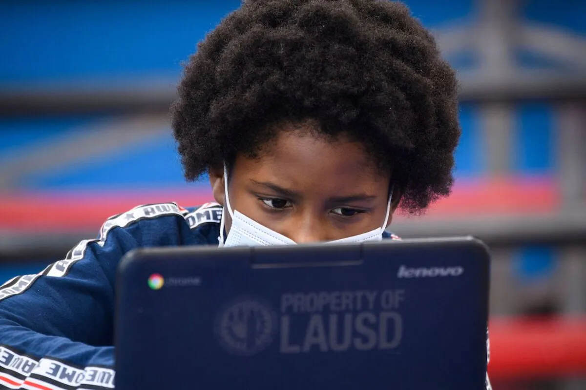 A child wears a face mask while attending an online class at a learning hub inside the Crenshaw Family YMCA during the Covid-19 pandemic in Los Angeles, Calif., on Feb. 17, 2021. (Patrick T. Fallon/AFP via Getty Images)