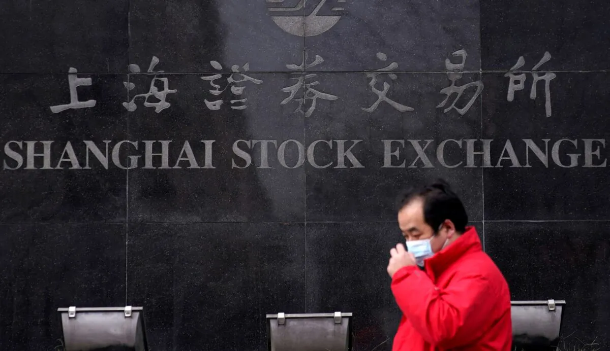 A men wearing a mask walk at the Shanghai Stock Exchange building at the Pudong financial district in Shanghai, China on Feb. 3, 2020. (Aly Song/Reuters)