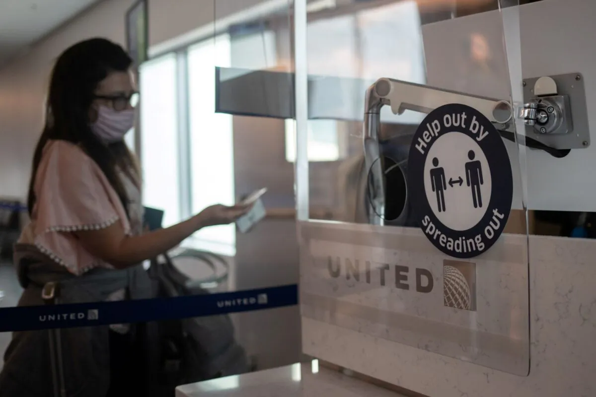 A passenger self scans her boarding pass to enter a United Airlines flight at IAH George Bush Intercontinental Airport amid the coronavirus disease outbreak in Houston, Texas on July 21, 2020. (Adrees Latif/Reuters)