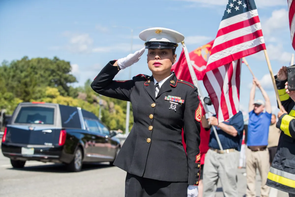 U.S. Marine Ssgt. Alice Ward stands at attention on the side of I-93 North as the hearse carrying fallen Marine Sgt. Johanny Rosario Pichardo passes in Stoneham, Mass., on Sept. 11, 2021.  (Scott Eisen/Getty Images)