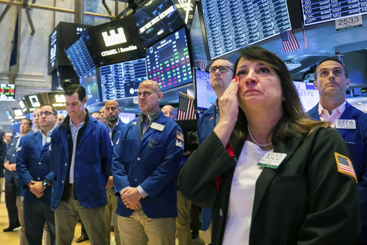 Floor traders, including Phyllis Arena Woods (R), gather in remembrance on the eve of Sept. 11, on the Exchange trading floor, on Sept. 10, 2021. (Courtney Crow/New York Stock Exchange via AP)