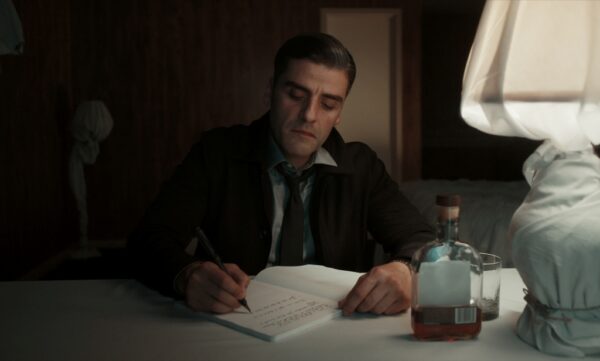 man writing and drinking