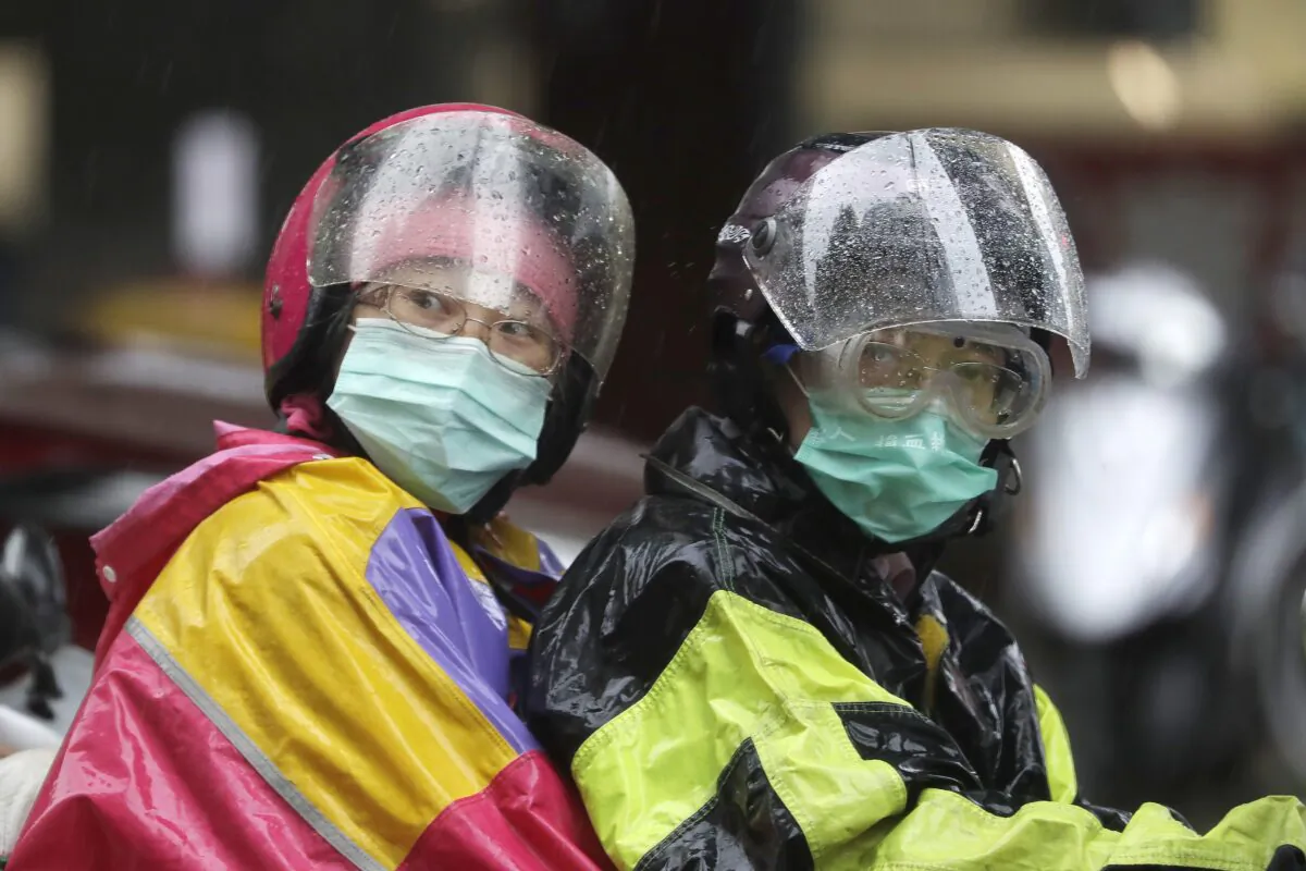 People ride a motorbike in the rain caused by Typhoon Chanthu in Taipei, Taiwan, on Sept. 12, 2021. (Chiang Ying-ying/AP Photo)
