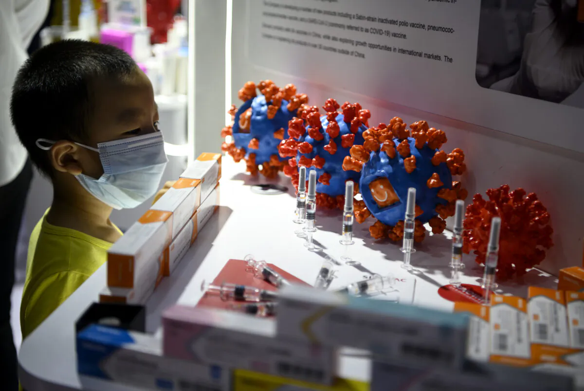 A boy looks at Sinovac Biotech's vaccine candidate for COVID-19 on display at the China International Fair for Trade in Services (CIFTIS) in Beijing on Sept. 6, 2020. (Photo by NOEL CELIS / AFP) (Photo by NOEL CELIS/AFP via Getty Images)