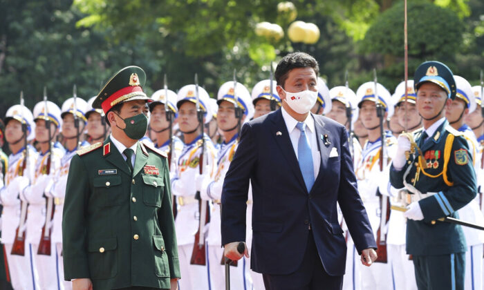 Vietnamese Defense Minister Phan Van Giang (L) and Japanese Defense Minister Nobuo Kishi review honor guards in Hanoi, Vietnam, on Sept. 12, 2021. (Nguyen Trong Duc/VNA via AP)