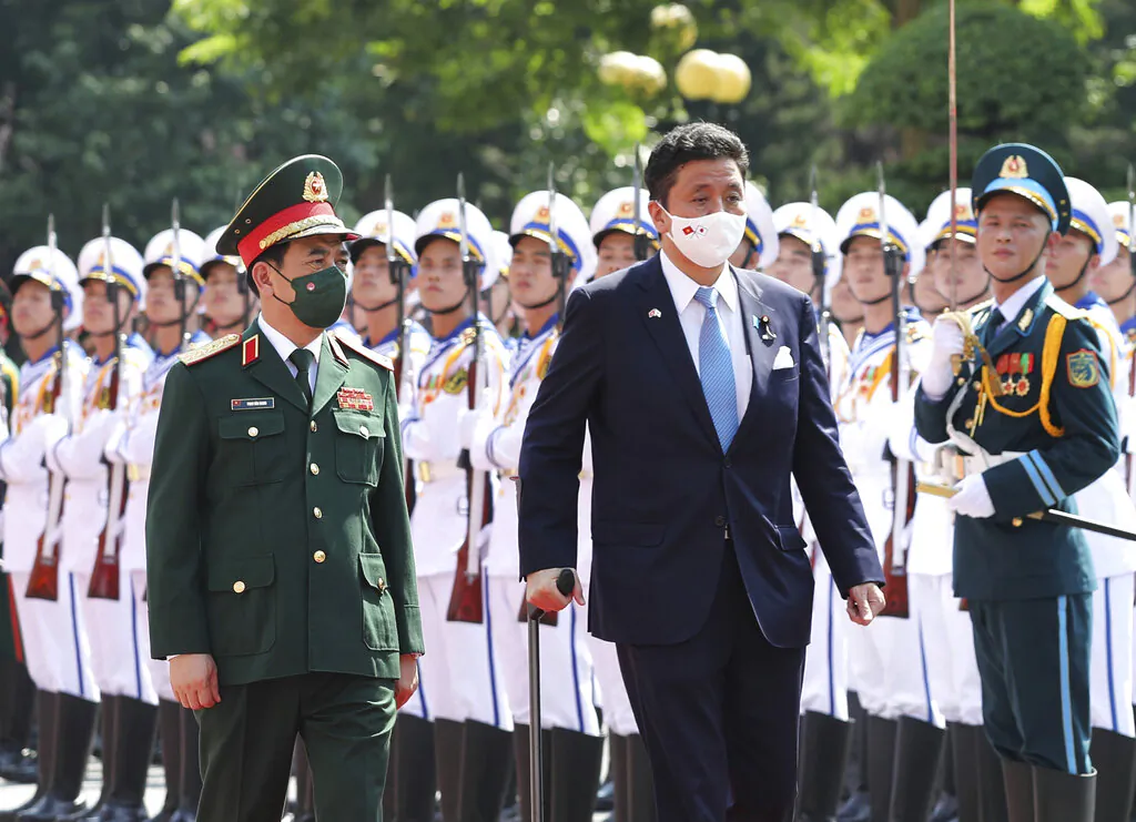 Vietnamese Defense Minister Phan Van Giang (L) and Japanese Defense Minister Nobuo Kishi review honor guards in Hanoi, Vietnam, on Sept. 12, 2021.  (Nguyen Trong Duc/VNA via AP)