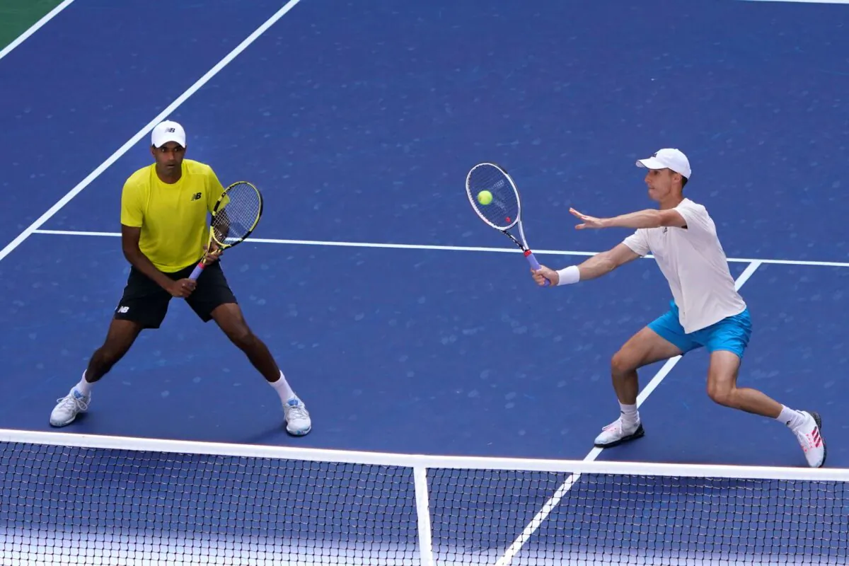 Joe Salisbury, of Great Britain, returns the ball as teammate Rajeev Ram, of the United States, watches during their men's doubles final match against Bruno Soares, of Brazil, and Jamie Murray, of Great Britain, at the U.S. Open tennis championships in New York on Sept. 10, 2021. (Elise Amendola/AP Photo)
