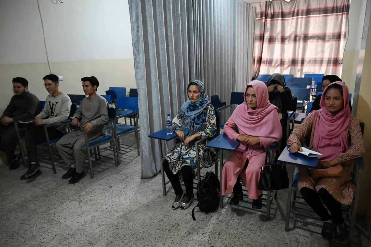 Students attend a class bifurcated by a curtain separating males and females at a private university to follow the Taliban's ruling, in Kabul on Sept. 7, 2021. (Aamir Qureshi/AFP via Getty Images)