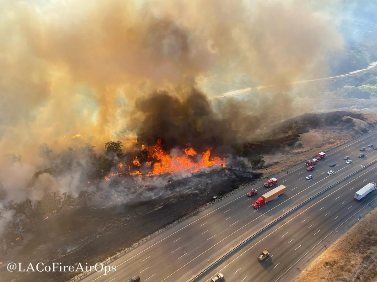 In this aerial photo released by the Los Angeles County Fire Department Air Operations traffic passes the Route fire, a brush wildfire off Interstate 5 north of Castaic, Calif., on Sept. 11, 2021. (Los Angeles County Fire Air Operations via AP)