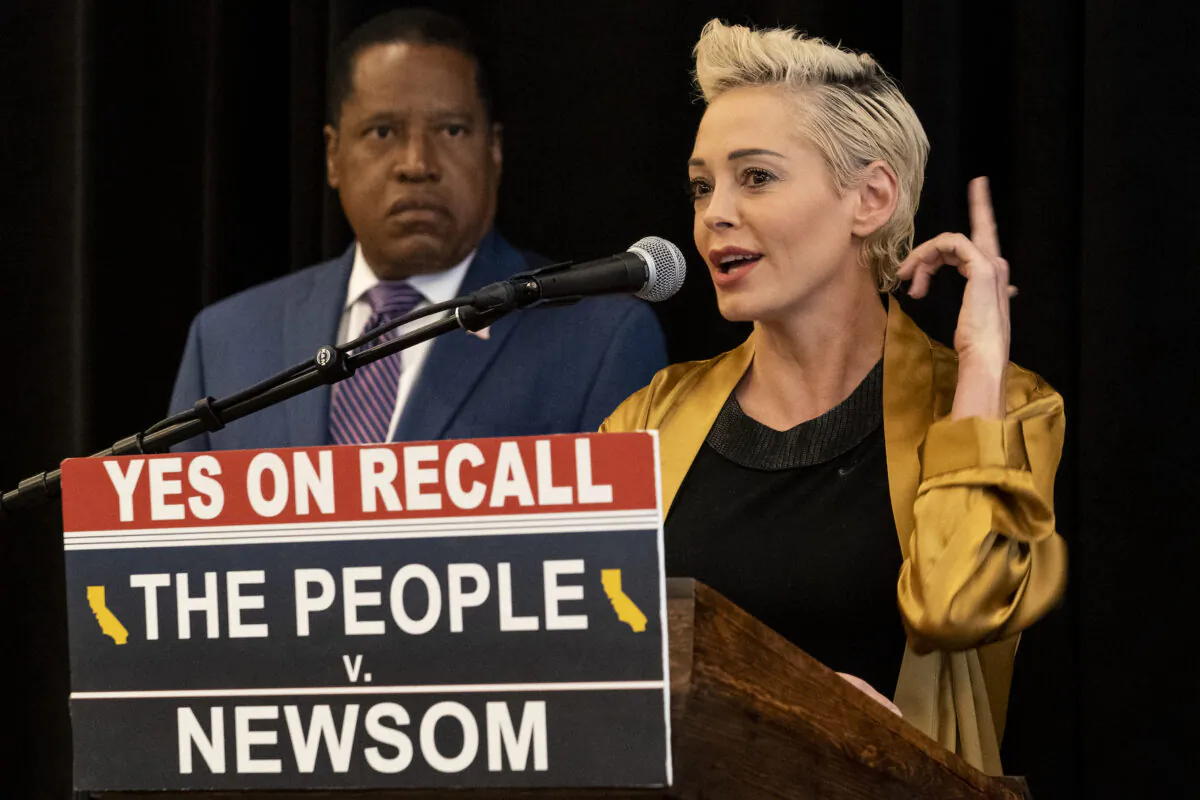 Republican conservative radio talk show host Larry Elder, left, listens as former actress and activist Rose McGowan speaks as the pair hold a news conference at the Luxe Hotel Sunset Boulevard in Los Angeles on Sept. 12, 2021. McGowan, who was one of the earliest of dozens of women in the #MeToo movement to accuse Hollywood producer Harvey Weinstein of sexual misconduct, has endorsed Elder for governor in California's recall election. (AP Photo/Damian Dovarganes)