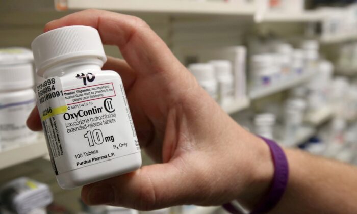 A pharmacist holds a bottle of OxyContin made by Purdue Pharma, at a pharmacy in Provo, Utah, on May 9, 2019. (George Frey/Reuters)