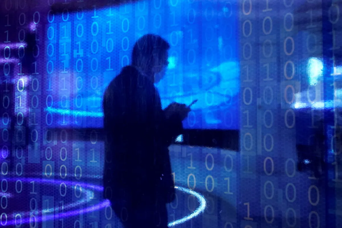 A man looking at a phone is seen through a digitally decorated glass during the World Internet Conference (WIC) in Wuzhen, Zhejiang province, China, on Nov. 23, 2020. (Aly Song/Reuters)