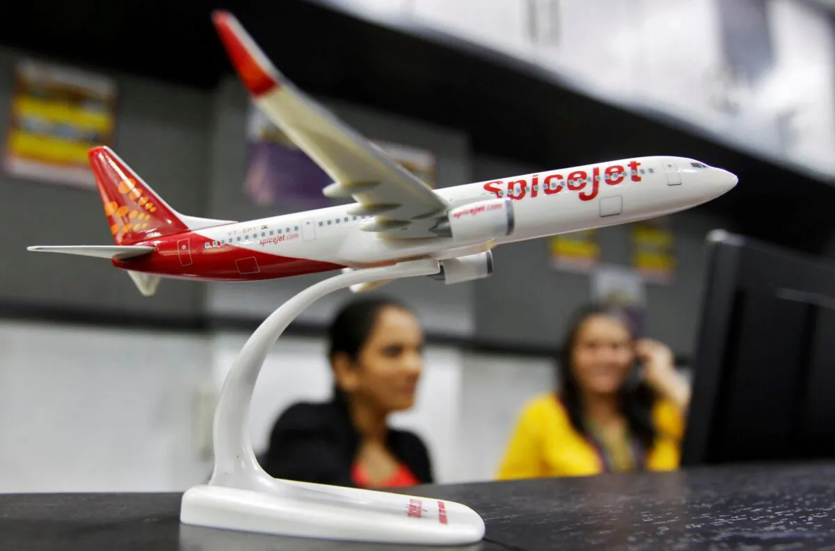 Employees work inside a travel agency office beside a model of a SpiceJet aircraft in the western Indian city of Ahmedabad on Feb. 14, 2014. (Amit Dave/Reuters)