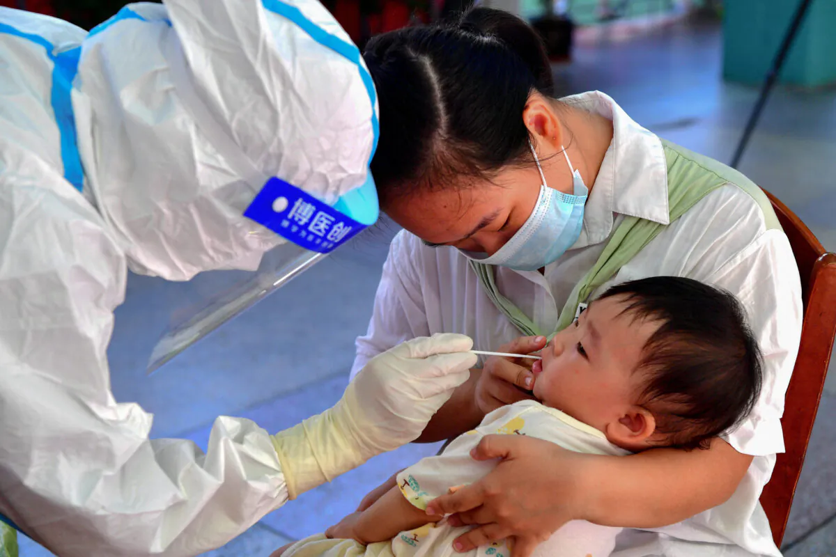 A child undergoes a nucleic acid test for the Covid-19 coronavirus in Xianyou county, Putian city, in China's eastern Fujian province on Sept. 13, 2021. (-/CNS/AFP via Getty Images)